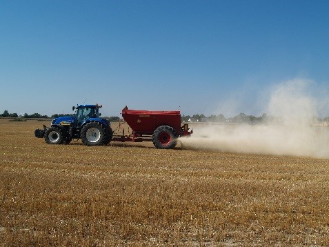 Traktor på stubbåker som kalkar